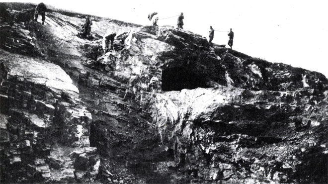 Рабочие на склоне холма Кости Дракона над древней пещерой, где начались раскопки